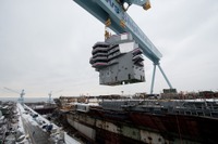巨大なクレーンによって原子力空母ジェラルド・R.フォードの甲板に下ろされる艦橋 画像