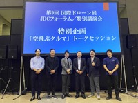 「空飛ぶクルマ」トークセッションの登壇者。左から丸紅 航空宇宙・防衛事業部 航空第三課長 吉川祐一氏、ANAホールディングス 未来創造室 モビリティ事業創造部 エアモビリティ事業グループリーダー 保理江裕己氏、日本航空 エアモビリティ創造部 マネージャー 佐々木康人氏、JDC会長を務める野波健蔵氏、SkyDrive CSO(最高戦略責任者) 村井宏行氏、AirX 代表取締役CEO 手塚究氏