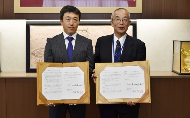 熊本県山鹿市役所で行われた契約締結調印式の様子。山鹿市長の中嶋憲正氏（右）とブリヂストン熊本工場長の原島寛氏