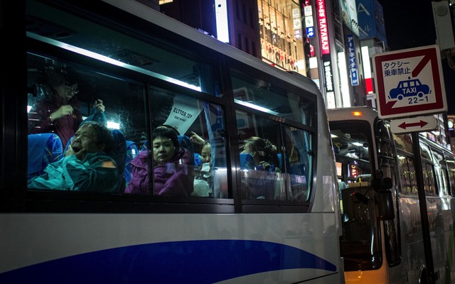 東京銀座にバスで乗り付ける外国人観光客