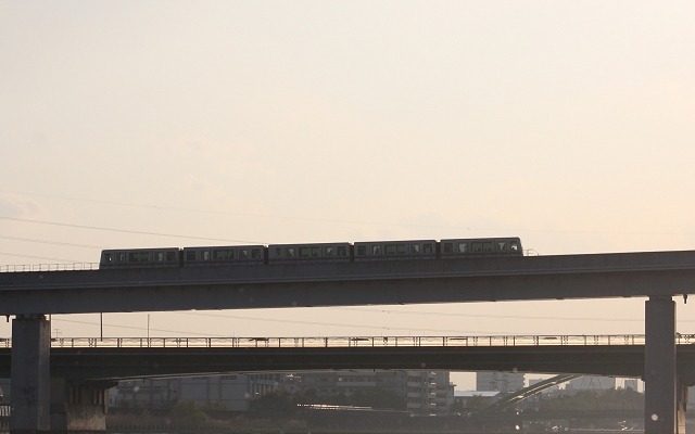 夕日を浴びながら隅田川を渡る日暮里・舎人ライナーの列車。5月29日に開業後8回目となるダイヤ改正が行われる。