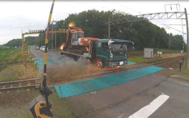 トロリ線に接触し、重機から火花を散らすダンプカー。
