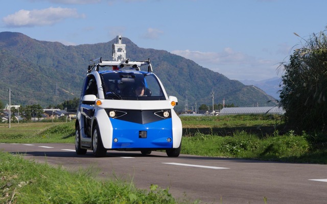 永平寺参ろーどで走行試験中の自動運転EVコミューター。全長2.5m・2人乗りの小型車で、公道に準じた場所での実験は、今回が初めてという。