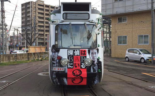 ロケの支援を行なった札幌フィルムコミッションのロゴや、札幌市シティプロモート戦略のサッポロスマイルロゴも装飾された「探偵はBARにいる3」ラッピング電車。