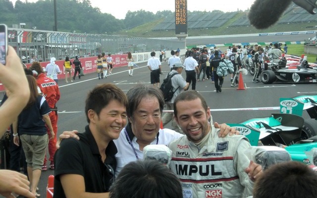 勝ったオリベイラ（右）と祝福する星野一義監督（中央）。星野監督に呼ばれて、かつての自軍エース・本山哲（左）も飛び入りで肩を組む