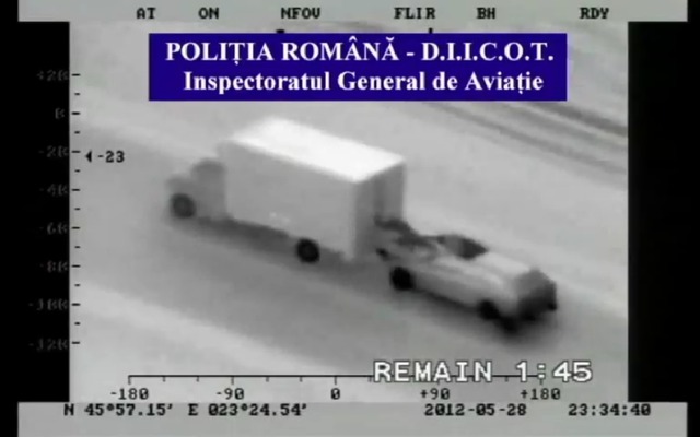 ルーマニア警察が捉えた窃盗団の映像。走行中のSUVのサンルーフから人が這い出し、トラックのリアゲートを開けようとしている