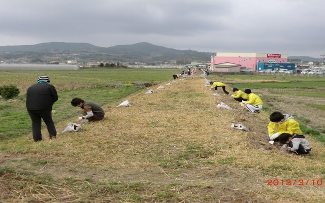 島原鉄道の廃線跡で種まきを行う地元住民。