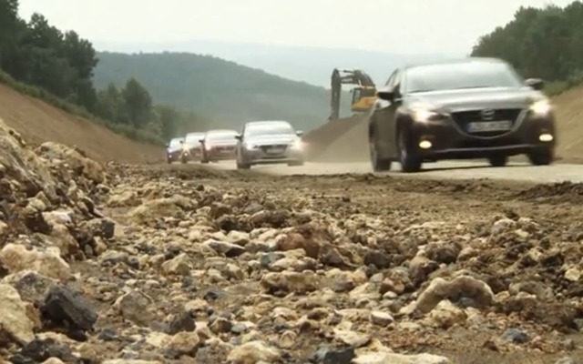 ロシアの荒れた道路を走行する新型マツダアクセラ