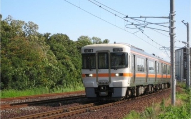 東成岩駅付近を走る武豊線の気動車。既に架線柱の設置と架線の敷設が完了している。