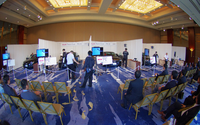 サービス部門の競技会場。ブース内で上着を着ているのが競技者。ポロシャツは審査員。手前の席では各店舗から駆けつけた応援が観戦する。