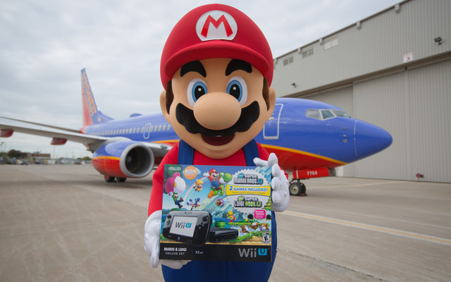 空港で任天堂のWii Uのゲーム機をプレゼントするマリオ