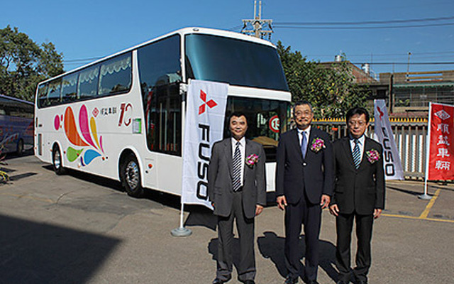 台湾向け大型バスの前で記念撮影をする小亀副社長（中央）および順益車輛関係者