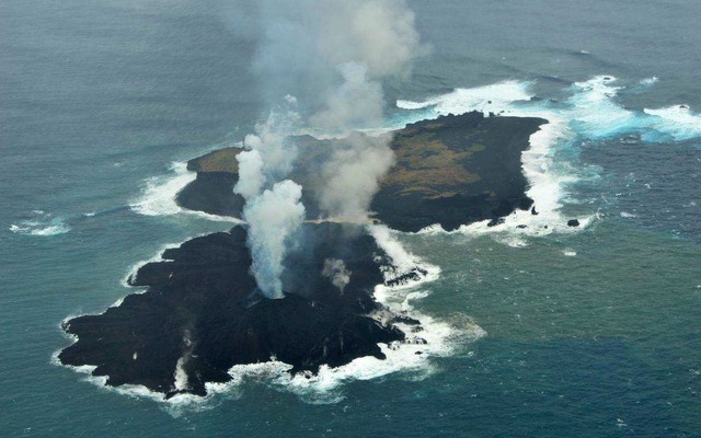 海上保安庁が2013年12月26日に撮影した西之島（奥）と新しい島（手前）。新しい島の急速な拡大で両島がつながった。