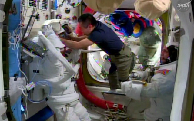 スティーブン・スワンソン宇宙飛行士（左）のヘルメットのフィットチェックを手伝う若田宇宙飛行士（4月17日撮影）（出典：JAXA／NASA）
