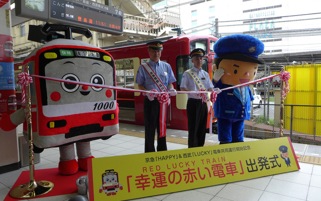 西武鉄道は7月19日から、京急カラーの「幸運の赤い電車」の運転を開始。池袋駅では両社のキャラクターや駅長が参加し、出発式が開かれた