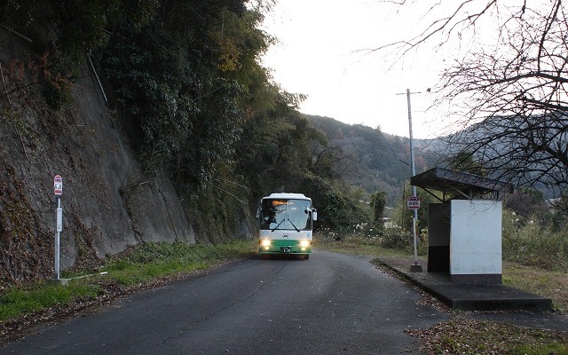 五新線の線路敷地を転用したバス専用道の賀名生停留所（賀名生駅予定地）を通過する12系統のバス。9月30日限りで廃止され、10月1日からは並行する国道を走るバスが増便される。