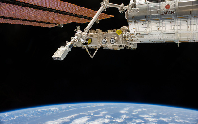 ISS「きぼう」モジュールの外側でロボットアームに把持された状態のナノラックス衛星放出機構