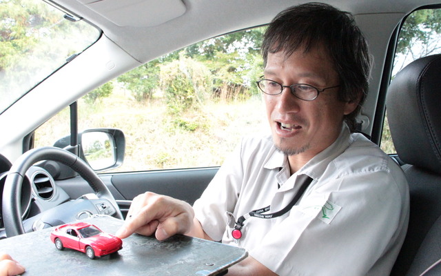 マツダ 操安性能開発部の虫谷泰典氏。RX-7のミニカーで車体の浮き沈みを解説する