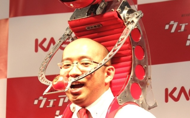 ウェアラブルトマトを使って、口元にトマトを運んでいるところ