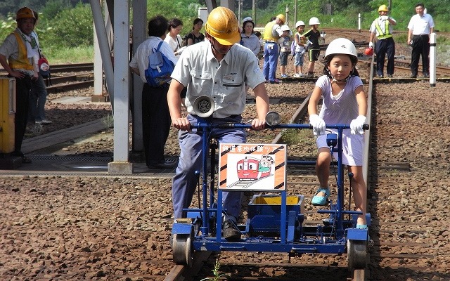 秋田内陸縦貫鉄道の子供向け車両基地公開イベントは8月に行われる。写真は軌道バイク体験の様子。