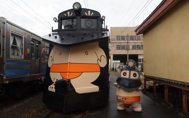 青森県の弘南鉄道でこのほど、子どもたちがラッセル車キ100形にラッピングを施すイベントが開かれた。マスコットキャラクター「ラッセル君」（右）デザインのラッピングを施したキ100形