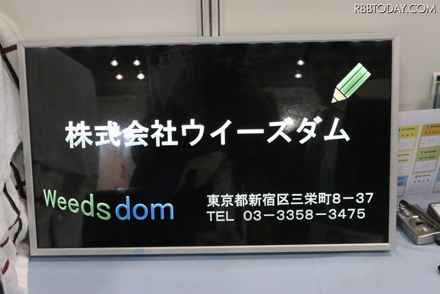こちらはアクリル彫刻版タイプ。デザインは社名やロゴに合わせカスタムメイドで製作可能。スペースが限られた壁面などへの設置も可能(撮影:防犯システム取材班)