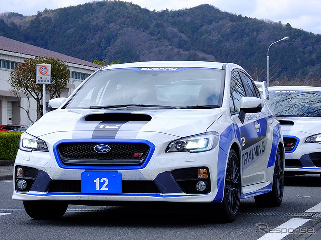 高速周回路バスツアーの横を220km/h超えで突っ走る、スバルドライビングアカデミートレーニング車(3月27日、栃木県佐野市・スバル研究実験センター)