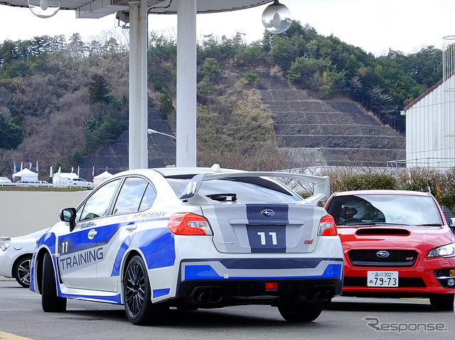 高速周回路バスツアーの横を220km/h超えで突っ走る、スバルドライビングアカデミートレーニング車(3月27日、栃木県佐野市・スバル研究実験センター)