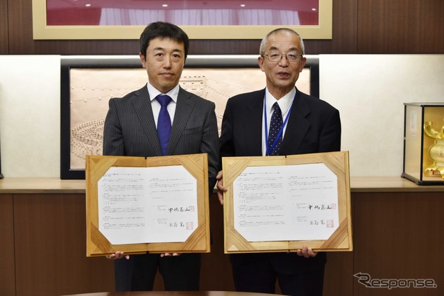 熊本県山鹿市役所で行われた契約締結調印式の様子。山鹿市長の中嶋憲正氏(右)とブリヂストン熊本工場長の原島寛氏