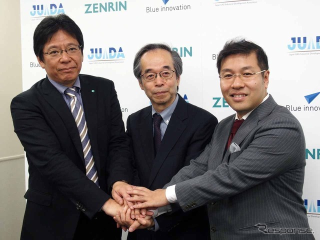 握手を交わす3名。(左から)ゼンリン上席執行役員第二事業本部長の藤沢秀幸氏、JUIDA代表理事の鈴木真二氏、ブルーイノベーション代表取締役社長の熊田貴之氏