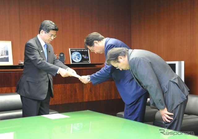 燃費データ不正を修正した新たな燃費値が確定し、石井国交相から指示書を受け取る三菱自・益子会長と相川社長（21日）