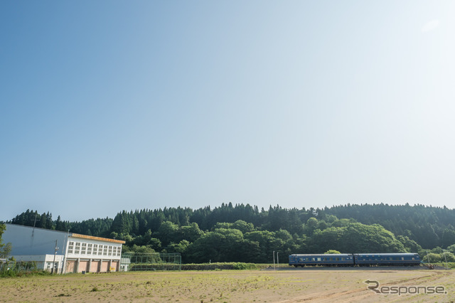 広々とした旧中学校のグラウンドに佇む状態。左側の建物は体育館。