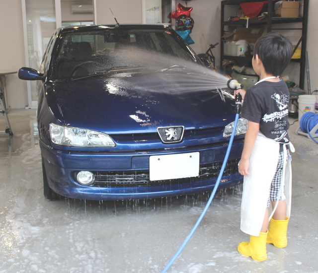 カーシャンプーの泡を水で洗い流している様子