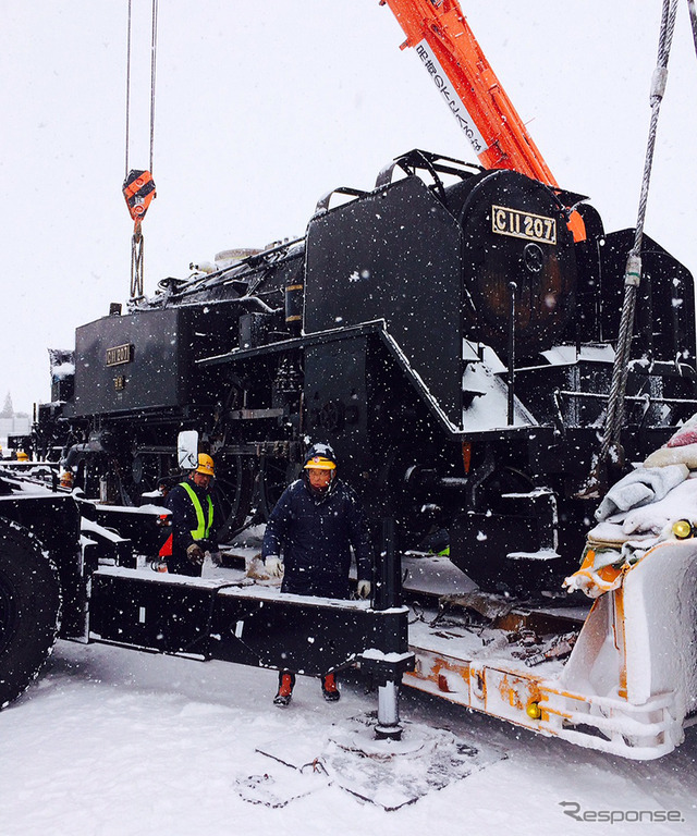 雪降るなかトレーラーに載せられる C11 207