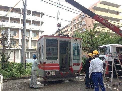本社敷地内で設置作業が行われている551編成の「カットモデル」。9月25日にお披露目式が行われる。