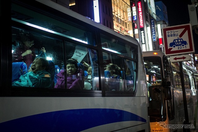 東京銀座にバスで乗り付ける外国人観光客