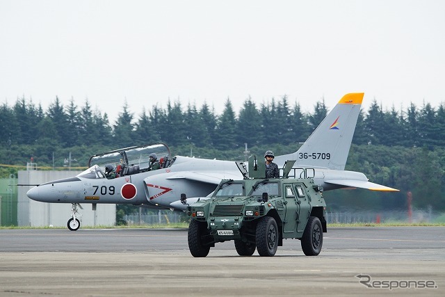 飛行展示に向かうT-4。軽装甲機動車(LAV)は警備のために武装している。