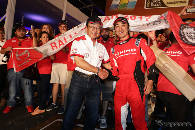 ポディウム上でがっちり握手する日野自動車の市川会長と菅原照仁