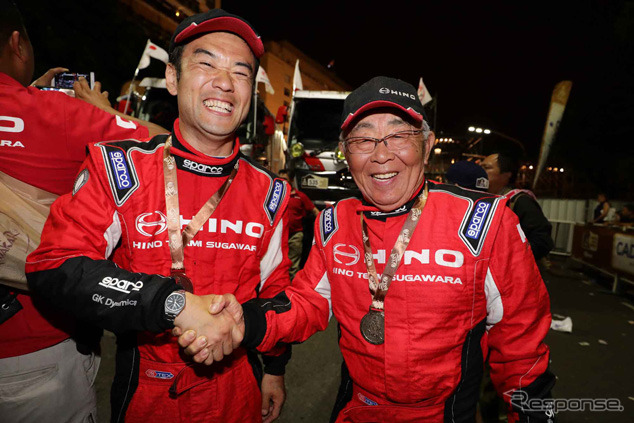 1号車ナビゲーターの高橋貢と握手する菅原義正