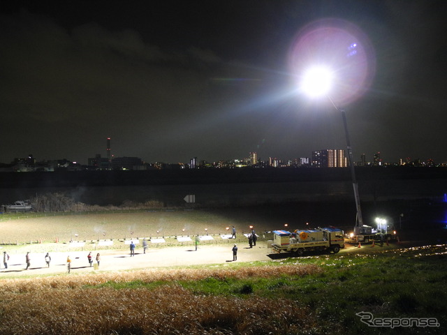 夜には照明車が河川敷を照らす