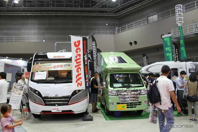 全長5ｍ超えのフルコンの横に軽キャンピングカーという日本のキャンピングカーショーらしい風景。