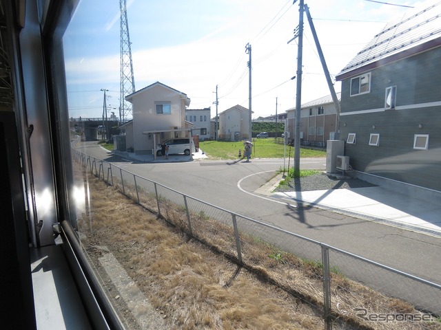 秋田港貨物支線の車窓。普段見られない旅客列車を珍しそうに眺める人がいた。