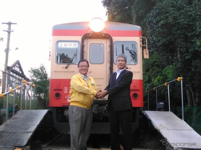姉妹鉄道協定の締結が決まり、いすみ鉄道キハ52形の前で握手を交わす、いすみ鉄道の鳥塚社長(左)と養老鉄道の都司(つじ)社長(右)。