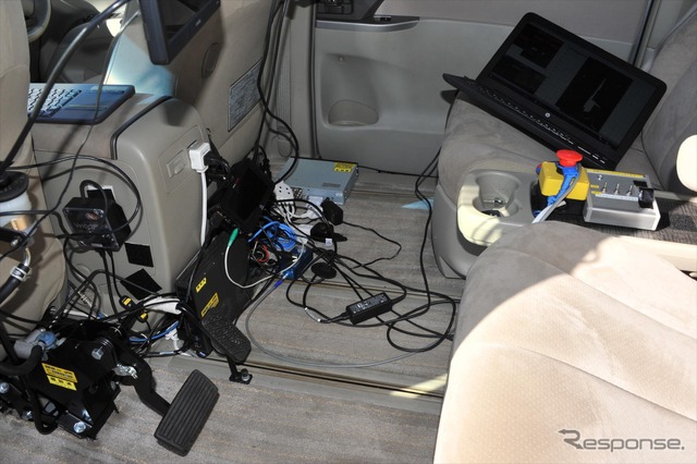 JARIの事前テストでは、自動運転車のイレギュラー対応を行うドライバーが、適切にブレーキを踏めるなど対応力も調べる。写真は慶應大学の開発車両の後席。左下にフットブレーキ、右上にエンジン停止ボタンがある。