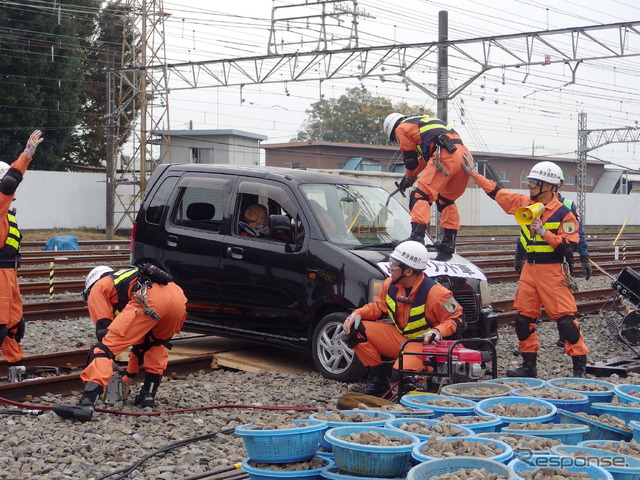 事故車はハイブリッド車なので、むやみに車体に触ると感電の恐れがある。そのため専門の救出チームが作業する。ボンネット上の隊員は専用の鋸でガラスを切っている。