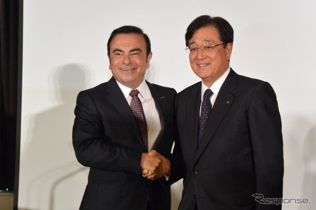 提携会見で握手する日産自動車カルロス・ゴーン社長と三菱自動車の益子修会長