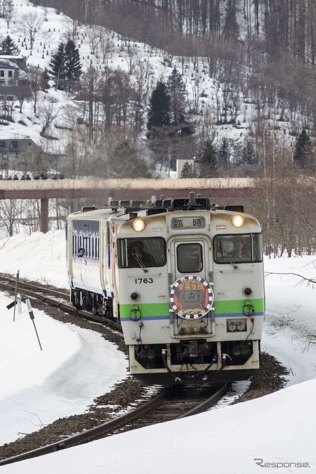 鹿ノ谷駅を出た新夕張行き列車。ヘッドマークは前後で異なるデザイン。車両も前からJR北海道色、「北海道の恵み」色、日高色と1両ずつ異なる塗色だった。2019年3月30日撮影。