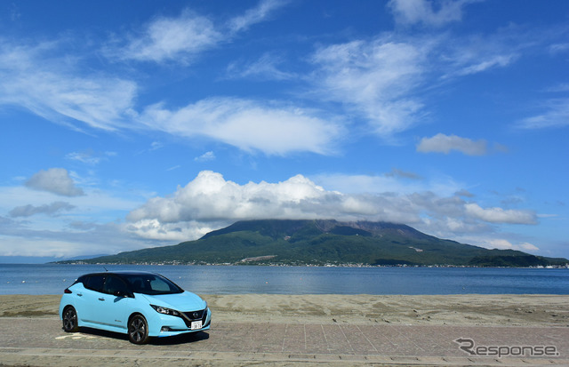 桜島をバックに記念撮影。背後の浜は海水浴場。