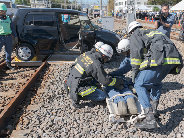 重傷のドライバーは担架で救急車に搬送する。