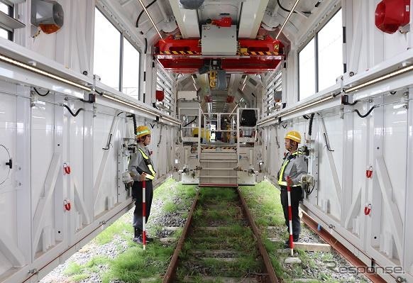 移動作業車：拡幅状況（2430mm→4430mm）。床がなく、車両にカバーされた状態で線路保守作業が可能だ。